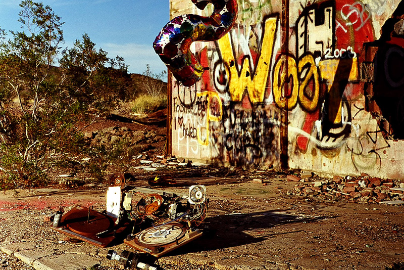 two abandoned turntables and a balloon in front of desert ruins
