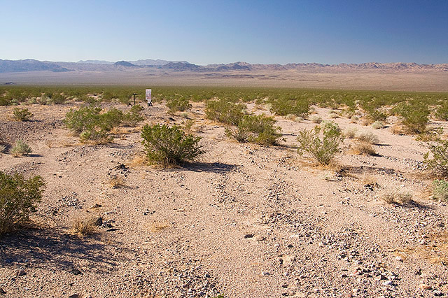 image of desert with sign, chair, and lecturn in the distance