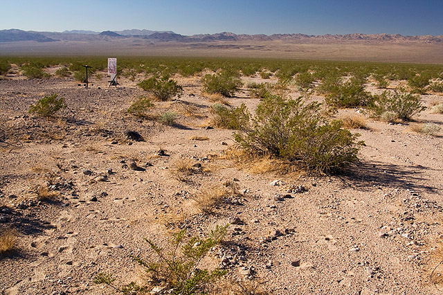 image of desert with sign, chair, and lecturn in the distance
