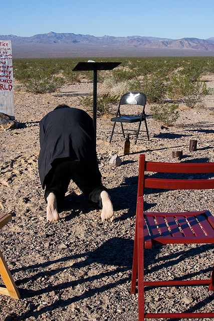preacher kneeling on the desert floor
