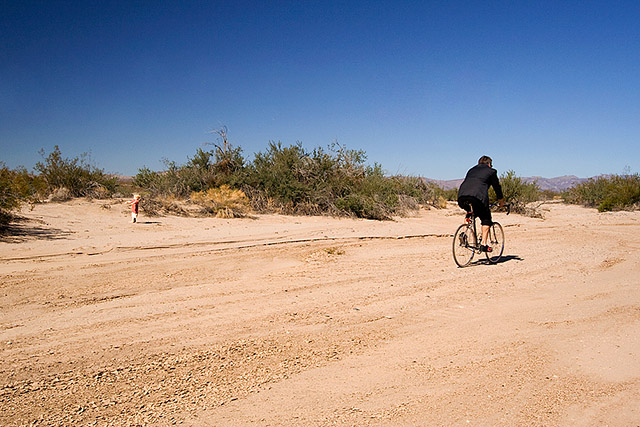 cyclist riding by toddler in the middle of nowhere