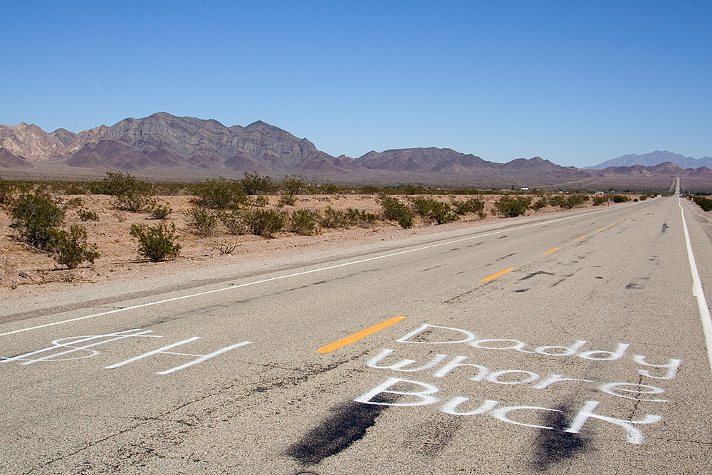 graffiti sprayed on route 66 in front of the road runner's retreat